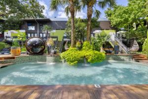 a large swimming pool with a wooden deck in front of a house at Modern Spacious 3 bed 3 12 bath suites in Dallas