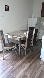 a dining room table with chairs and a refrigerator at Apartman5 in Gornja Toplica