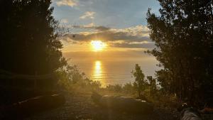 a sunset over the water with boats on the shore at Ko Glamping in Valdivia +36 photos