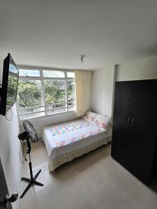 Un dormitorio pequeño con una cama y una ventana. en Apartaestudios centro ibague, en Ibagué
