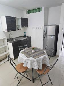 Una cocina con una mesa y sillas en una cocina. en Apartaestudios centro ibague, en Ibagué