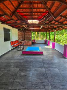 a large patio with red chairs and a table at Palms & Peace - A Serene getaway with hill view By Shivalaya in Coimbatore