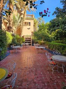 un patio avec des tables et des chaises et un bâtiment dans l'établissement Chez Ali, à Zagora 177 autres photos