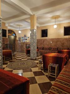 un restaurant avec des tables et des chaises dans une salle dans l'établissement Chez Ali, à Zagora