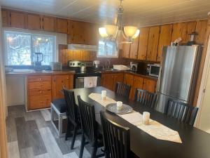 une cuisine avec une table, des chaises et un réfrigérateur dans l'établissement Maison de vacances, à Rivière-Rouge