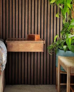 ein Holzregal an einer Wand mit einer Pflanze in der Unterkunft High Tree - Stylish Detached Home - South Park and Town Centre in Macclesfield