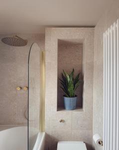 ein Badezimmer mit einem WC und einer Topfpflanze in der Unterkunft High Tree - Stylish Detached Home - South Park and Town Centre in Macclesfield