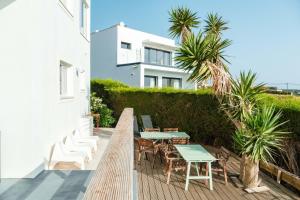 un patio avec des tables et des chaises et un bâtiment dans l'établissement Arrifana Surf Camp, à Aljezur