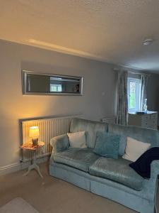 Una sala de estar con un sofá y una ventana. en Spacious Two-Bedroom Guest Suite, Exmouth, en Lympstone