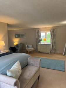 1 dormitorio con cama, sofá y sala de estar en Spacious Two-Bedroom Guest Suite, Exmouth, en Lympstone