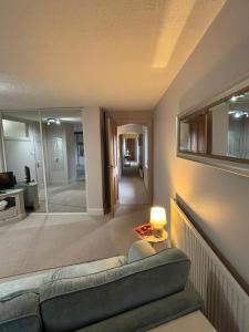 Una sala de estar con un sofá y una lámpara. en Spacious Two-Bedroom Guest Suite, Exmouth, en Lympstone