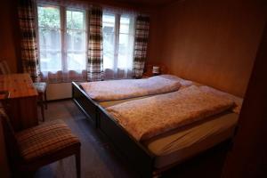 une chambre avec deux lits et une fenêtre dans l'établissement Bühlengasse 6, à Grindelwald