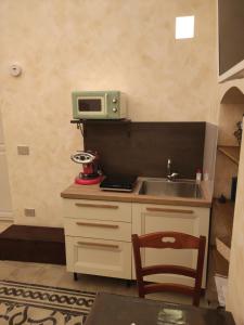 une cuisine avec un évier et un micro-ondes sur un comptoir dans l'établissement Ripa di sassi, à Manfredonia