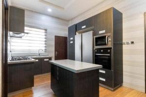 a kitchen with a refrigerator and a stove top oven at 3 bedroom Masionette in Lekki