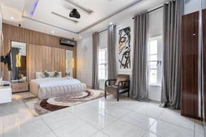 a large bedroom with a bed and a chair at 3 bedroom Masionette in Lekki