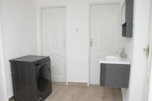 une salle de bains avec lave-linge et lavabo dans l'établissement Zeitahomes, à Cotonou