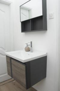 une salle de bain avec un lavabo et un miroir dans l'établissement Zeitahomes, à Cotonou