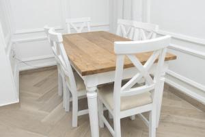 - une table à manger blanche avec 3 chaises blanches dans l'établissement Zeitahomes, à Cotonou 2 autres photos