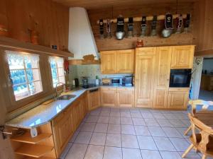 eine große Küche mit Holzschränken und einem Waschbecken in der Unterkunft Ferienhaus Schönenmatte in Zweisimmen
