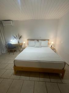 a bedroom with a large bed with two pillows at Cap Sounion Seafront Retreat in Sounio +17 photos