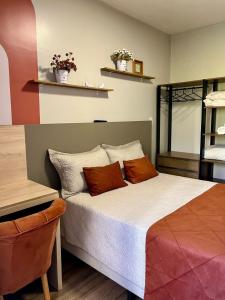 a bedroom with a bed with orange pillows on it at Kitnet no centro com garagem in Caxias do Sul +3 photos