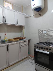 a kitchen with white cabinets and a stove top oven at Stone house in Amman