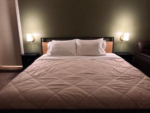 un lit avec des draps blancs et des oreillers dans une chambre dans l'établissement Creekside Cottage, Private, Peaceful, Cozy Escape, à Maryville