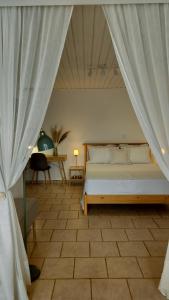 a bedroom with a bed with a curtain and a table at Cap Sounion Seafront Retreat in Sounio