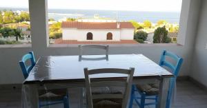 ein Tisch und Stühle in einem Zimmer mit Fenster in der Unterkunft Ferienwohnung für 4 Personen ca 56 m in Perd'e Sali, Sardinien Golf von Cagliari in Porto Columbu - Perdʼe Sali