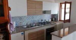 eine Küche mit Spüle und Herd in der Unterkunft Ferienwohnung für 4 Personen ca 56 m in Perd'e Sali, Sardinien Golf von Cagliari in Porto Columbu - Perdʼe Sali + 15 Fotos