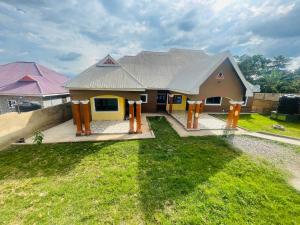 a small house with yellow and orange posts in the yard at AnKeS Lodge in Sunyani