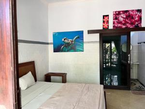 ein Schlafzimmer mit einem Bett und einem Bild einer Ente im Wasser in der Unterkunft Dhita Dive Bungalow in Ambat + 4 Fotos