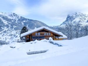 ein Blockhaus in den schneebedeckten Bergen in der Unterkunft Ferienhaus Chalet Simeli in Grindelwald