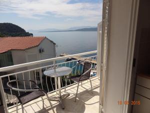 a balcony with a table and chairs and a view of the water at Komfortables Studio Apartment Mit Meerblick in Živogošće +32 photos
