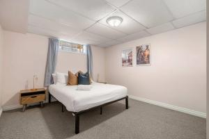 ein Schlafzimmer mit einem Bett und einem Fenster in der Unterkunft The Arizona 2BR Pet-Friendly Suite Calgary SE in Calgary