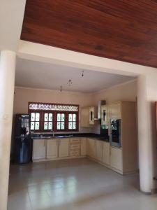 a large kitchen with white cabinets and a wooden ceiling at House for rent in Mirigama, Sri Lanka in Mirigama +19 photos