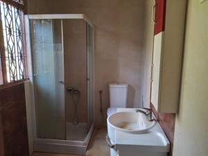 a bathroom with a shower and a toilet and a sink at House for rent in Mirigama, Sri Lanka in Mirigama