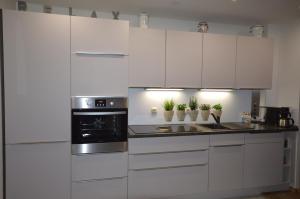 a kitchen with white cabinets and a stove at Komfortable Ferienwohnung In Waase Mit Garten in Ummanz