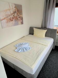 a bed with a blue bow on it in a room at Hotel Lamm in Pforzheim