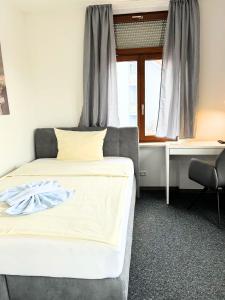 a bedroom with a bed and a window at Hotel Lamm in Pforzheim