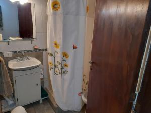 La salle de bains est pourvue d'un rideau de douche et de fleurs. dans l'établissement Tu Alojamiento en Mar del Plata, à Mar del Plata