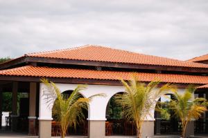 un bâtiment avec deux palmiers devant lui dans l'établissement São João Paulo II - Casa de Retiro, à Aquiraz