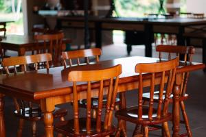 - une table et des chaises en bois dans un restaurant dans l'établissement São João Paulo II - Casa de Retiro, à Aquiraz