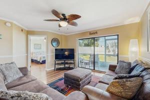 un soggiorno con un divano e un ventilatore a soffitto di Waterfront condo with community pools & hot tub - walk to the beach a St. Augustine