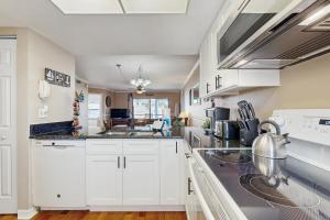 una cucina con mobili bianchi e una stufa di Waterfront condo with community pools & hot tub - walk to the beach a St. Augustine