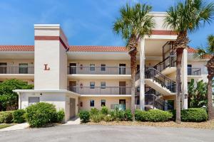 un grande condominio con palme di fronte di Waterfront condo with community pools & hot tub - walk to the beach a St. Augustine