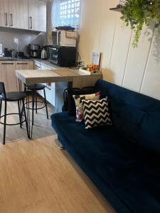 ein Wohnzimmer mit einer blauen Couch in einer Küche in der Unterkunft Casinha na serra para até 4 pessoas in Nova Petrópolis