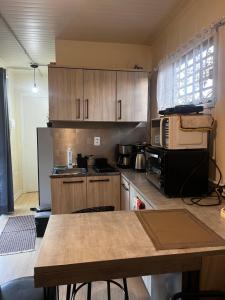 eine Küche mit Holzschränken und einer Arbeitsplatte in der Unterkunft Casinha na serra para até 4 pessoas in Nova Petrópolis