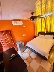 Un dormitorio con una cama con una pared naranja. en Hotel Leidy Resort, en Melgar