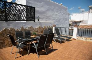 un patio avec des chaises et une table sur un balcon dans l'établissement Casa María en el centro Nerja, à Nerja
